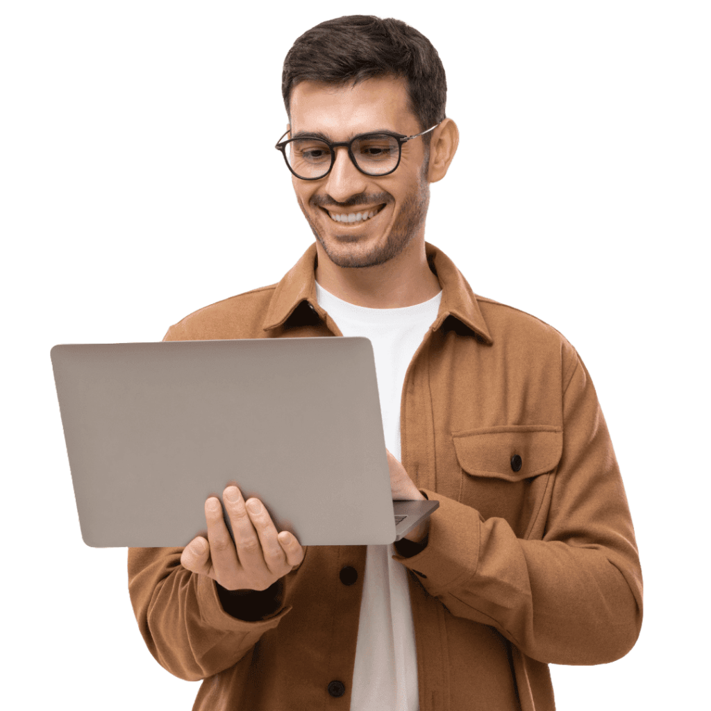 An attractive man with glasses who smiles and holds a laptop.